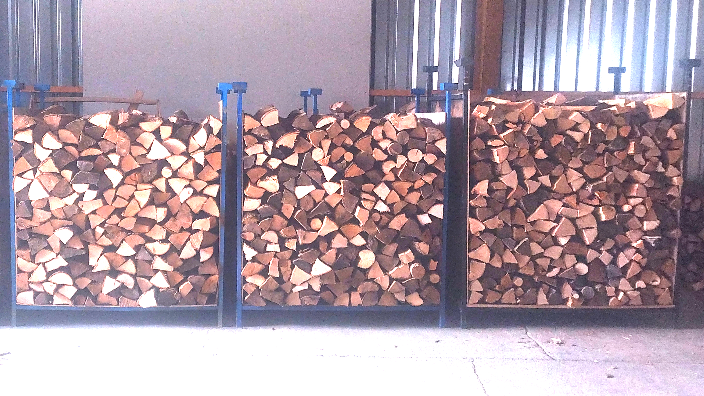 Trois caisses métalliques remplies de bois de chauffage